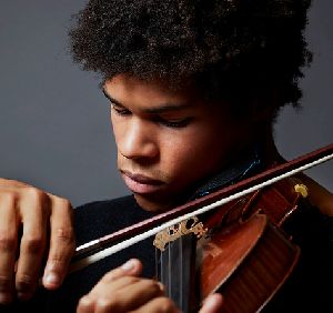 A close-up of Braimah Kanneh-Mason playing his violin